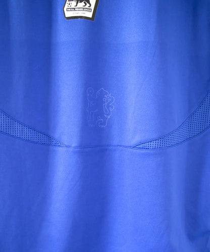 Maillot domicile de chelsea de la saison 2006/2008. Le maillot est floqué du numéro 7 Shevchenko. On peut retrouver l'équipementier adidas et le sponsor samsung. Sur cette photo on peut voir le petit lyon de chelsea incrusté dans le maillot