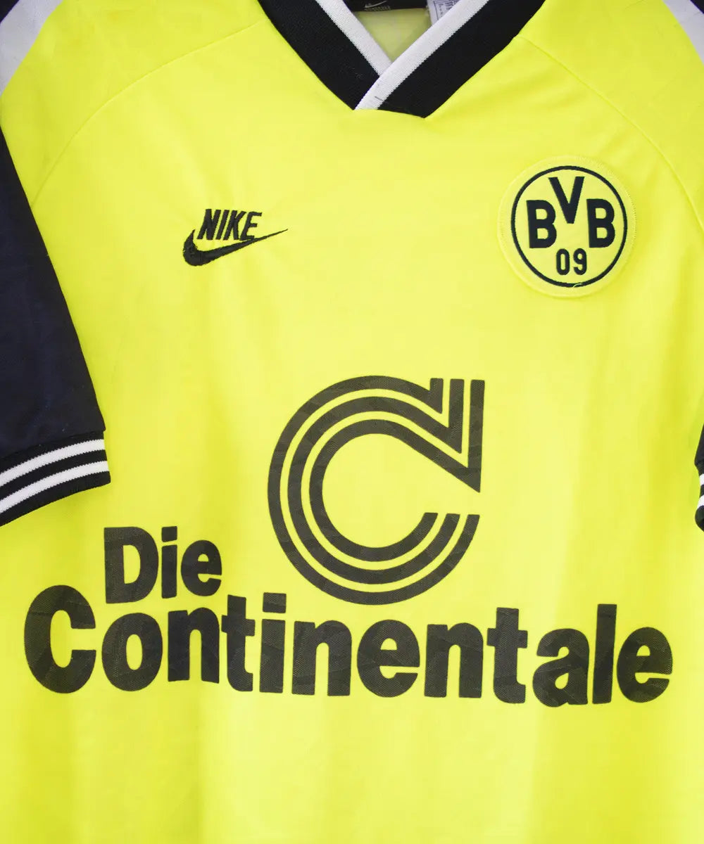 Maillot domicile du Borussia Dortmund de la saison 1995-1996. Le maillot est de couleur jaune et noir. On peut retrouver sur le maillot le sponsor die continentale et l'équipementier nike. Le maillot est floqué du numéro 10 Frank Möller. Sur cette photo on peut voir le sponsor die continentale de près