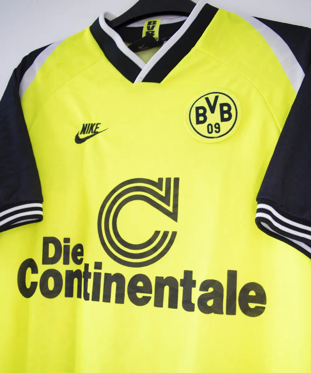 Maillot domicile du Borussia Dortmund de la saison 1995-1996. Le maillot est de couleur jaune et noir. On peut retrouver sur le maillot le sponsor die continentale et l'équipementier nike. Le maillot est floqué du numéro 10 Frank Möller. Sur cette photo on peut voir le sponsor die continentale de côté