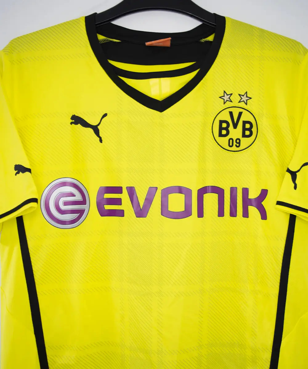 Maillot vintage domicile jaune et noir du borrussia dortmund de la saison 2013-2014. On peut retrouver l'équipementier puma et le sponsor evonik. Le maillot est floqué du numéro 9 Lewandowski