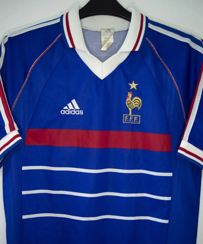 Maillot de foot vintage bleu blanc et rouge de l'équipe de france 1998. On peut retrouver l'équipementier adidas