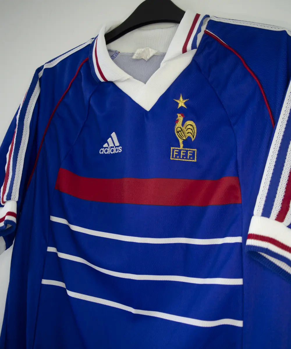 Maillot équipe de france 1998 domicile de couleur bleu, blanc et rouge. On peut retrouver l'équipementier adidas. Le maillot est floqué du numéro 10 Zidane