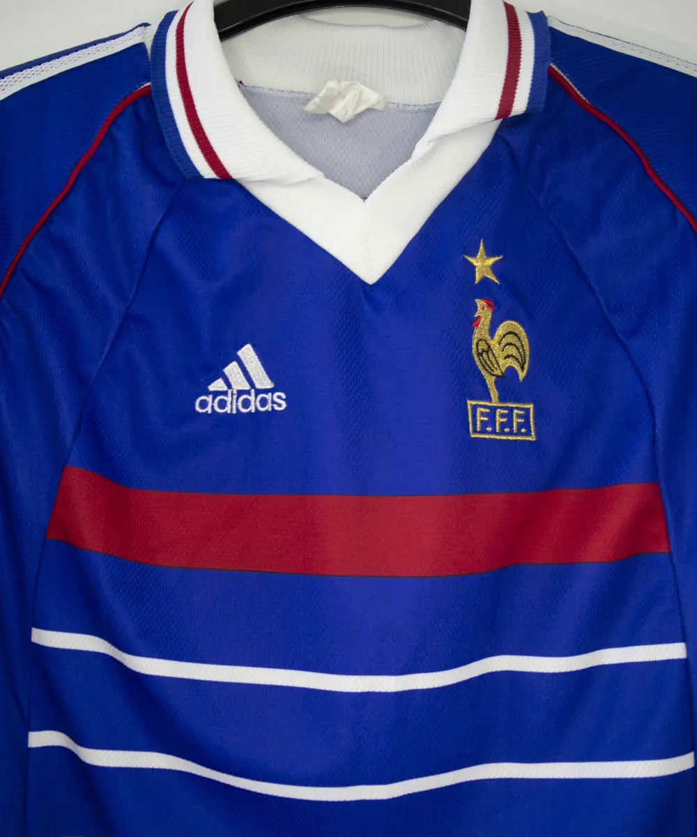 Maillot équipe de france 1998 domicile de couleur bleu, blanc et rouge. On peut retrouver l'équipementier adidas. Le maillot est floqué du numéro 10 Zidane