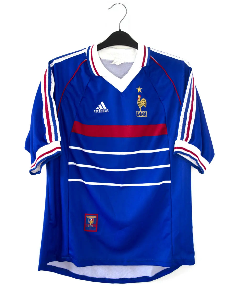 Maillot équipe de france 1998 domicile de couleur bleu, blanc et rouge. On peut retrouver l'équipementier adidas. Le maillot est floqué du numéro 10 Zidane