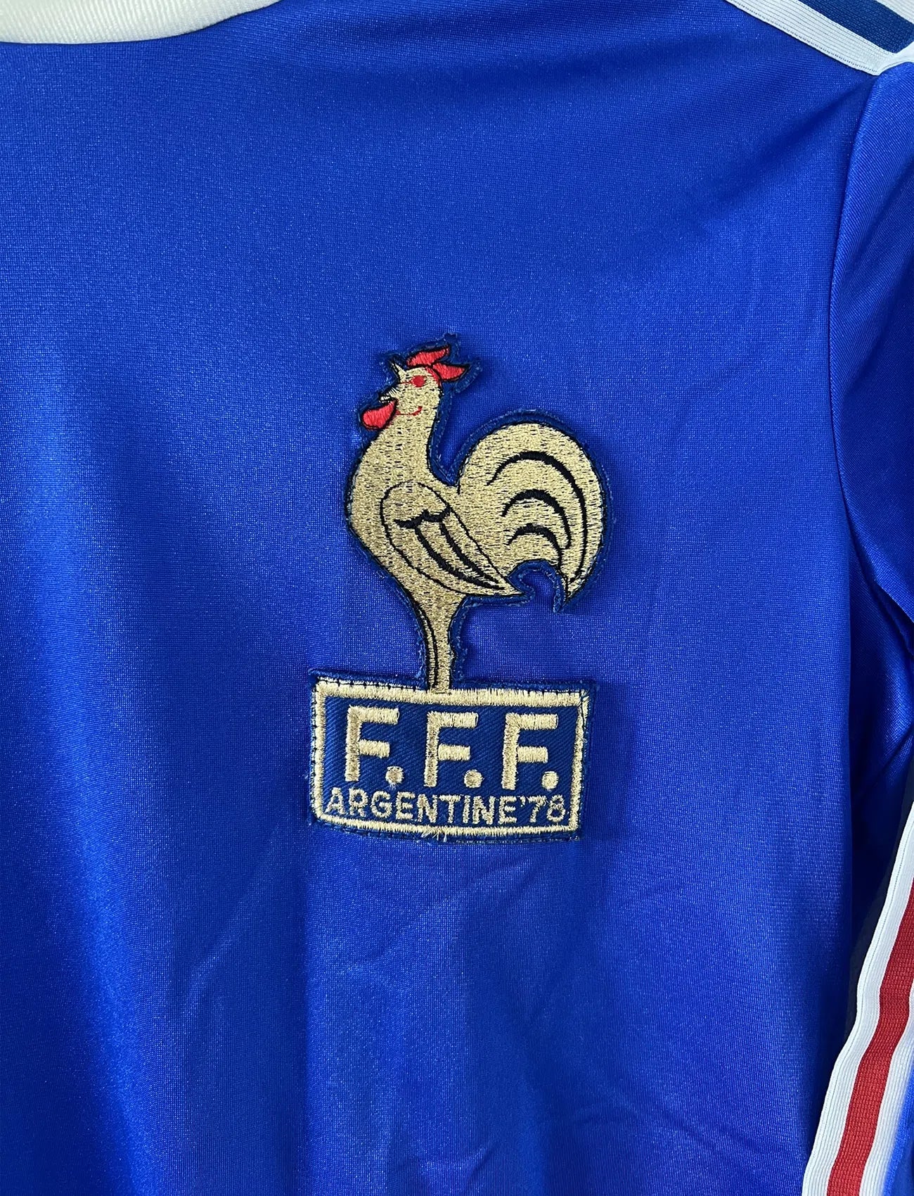 Maillot de foot vintage de l'équipe de france bleu blanc et rouge. Il s'agit du maillot domicile édité lors de la coupe du monde 1978. On peut retrouver l'équipementier adidas. Il s'agit d'un maillot authentique