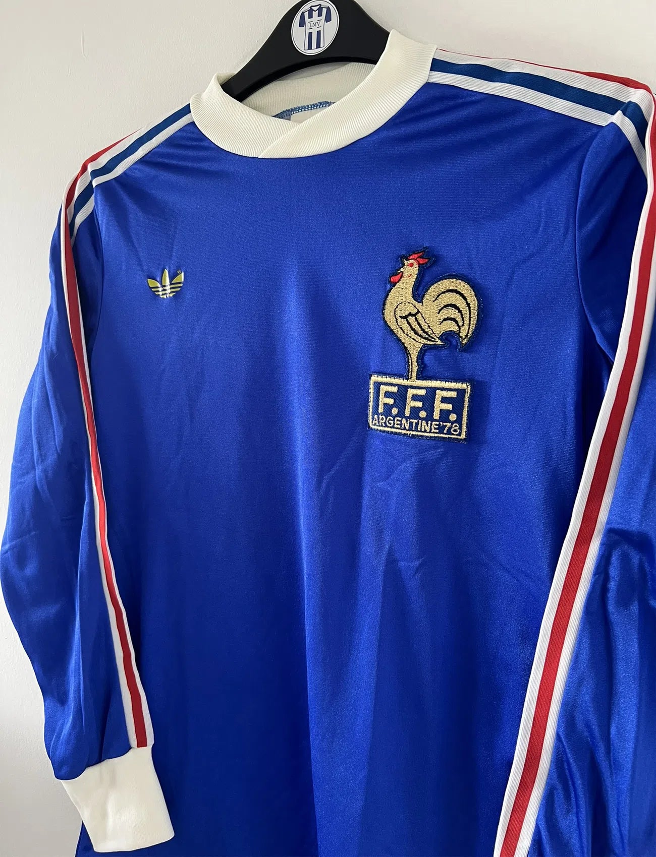Maillot de foot vintage de l'équipe de france bleu blanc et rouge. Il s'agit du maillot domicile édité lors de la coupe du monde 1978. On peut retrouver l'équipementier adidas. Il s'agit d'un maillot authentique