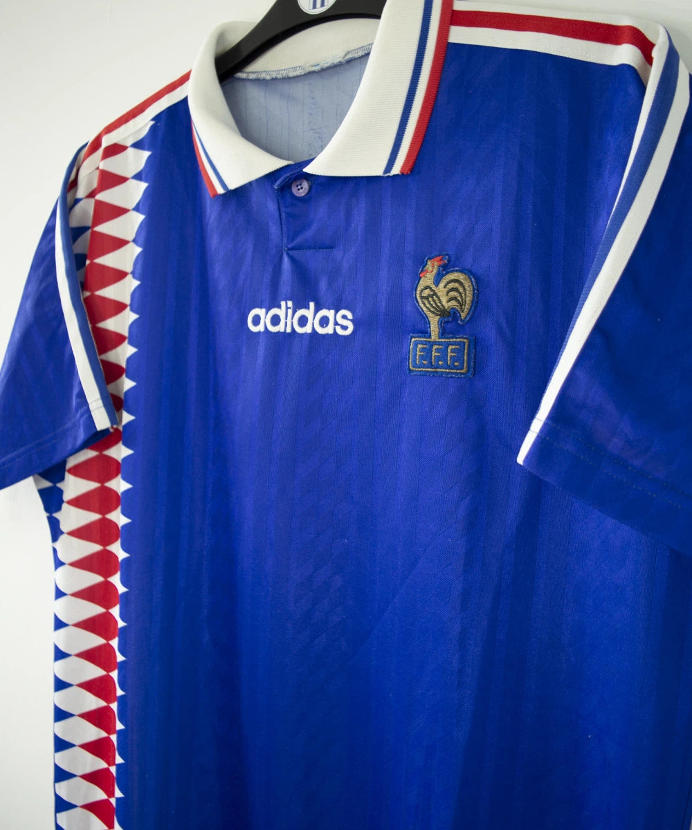 Maillot de foot vintage bleu blanc et rouge de l'équipe de france 1994. On peut retrouver l'équipementier adidas. Il s'agit d'un maillot authentique