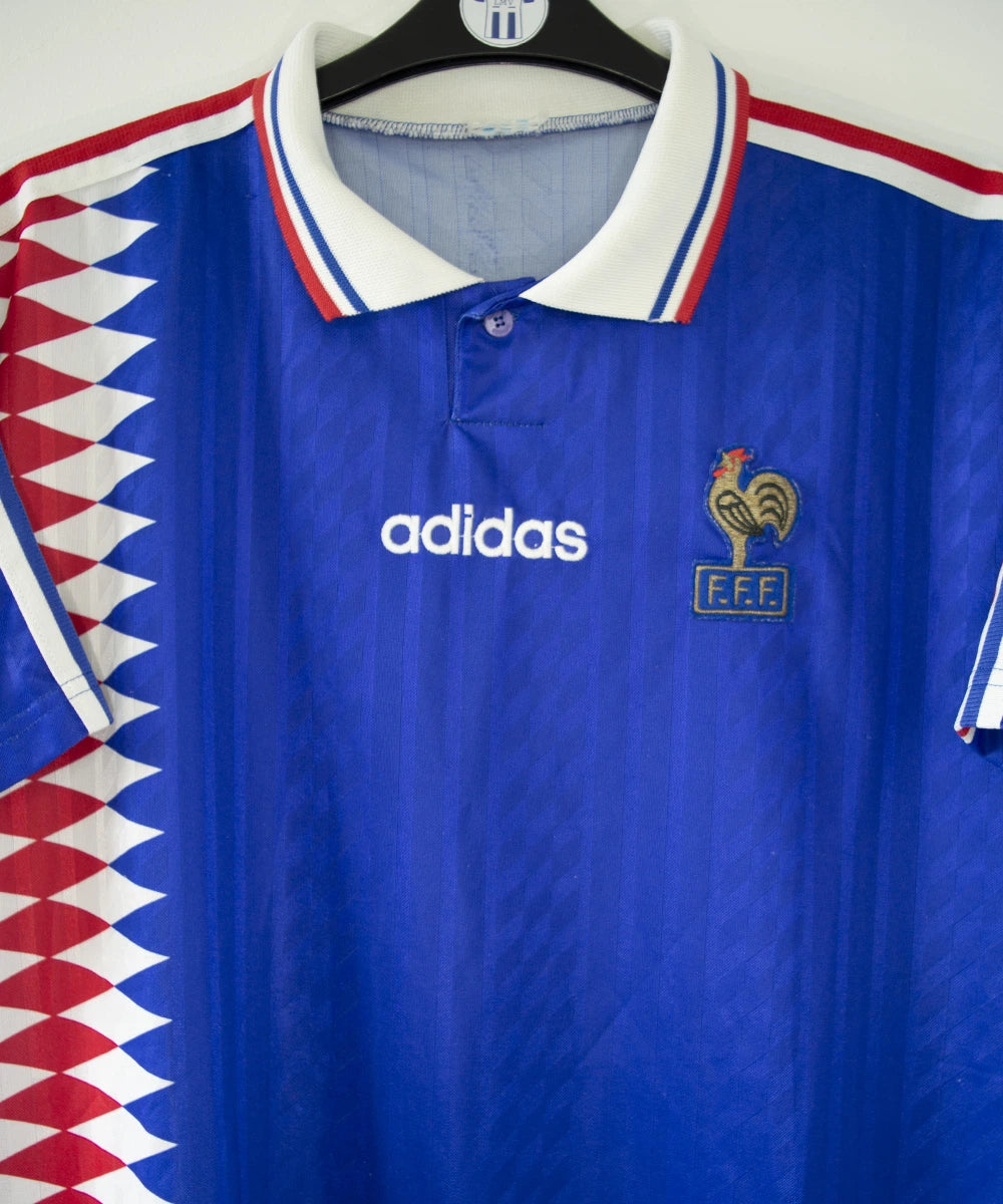 Maillot de foot vintage bleu blanc et rouge de l'équipe de france 1994. On peut retrouver l'équipementier adidas. Il s'agit d'un maillot authentique