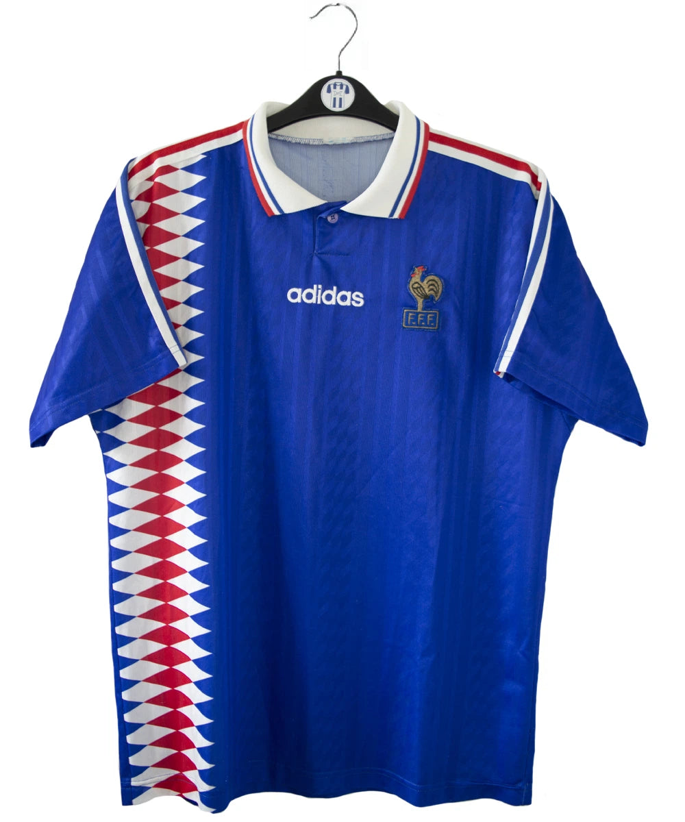 Maillot de foot vintage bleu blanc et rouge de l'équipe de france 1994. On peut retrouver l'équipementier adidas. Il s'agit d'un maillot authentique