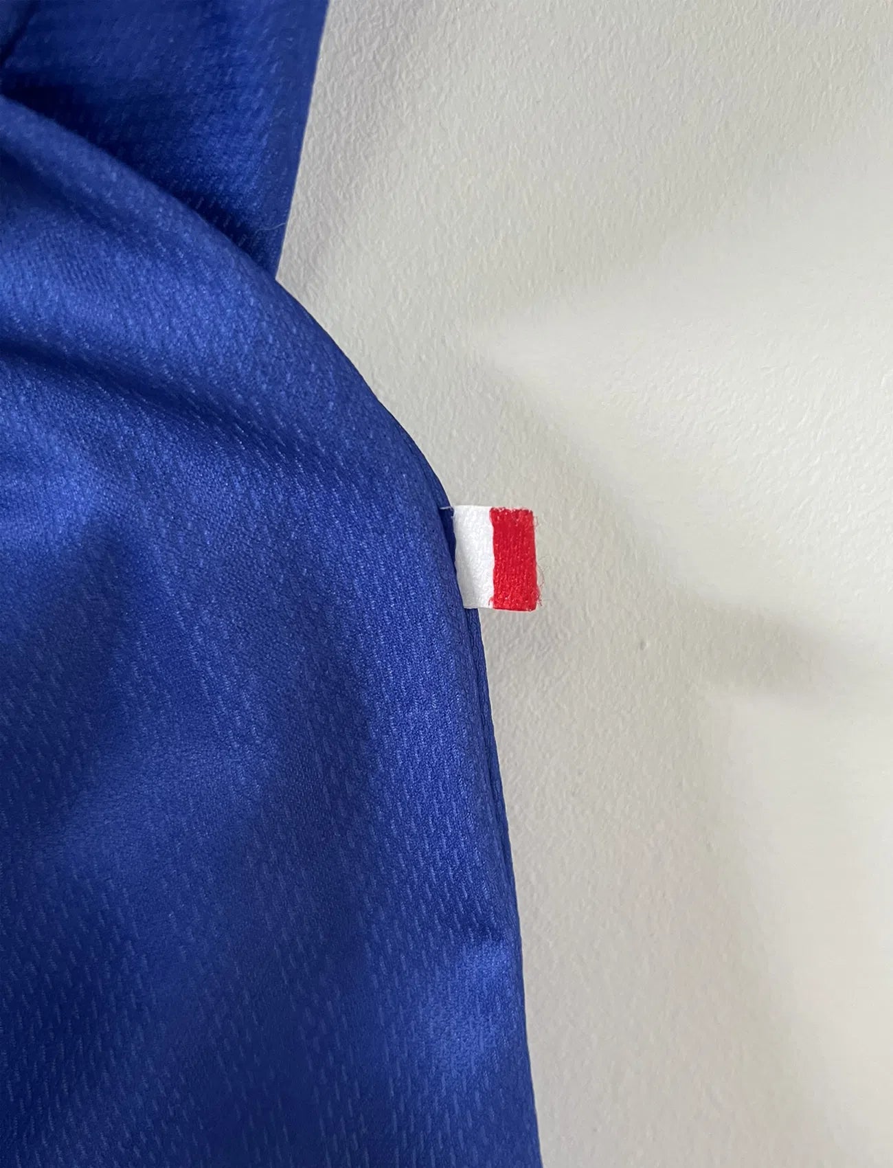 Maillot de foot vintage de l'équipe de france bleu blanc et rouge. Il s'agit du maillot domicile de la coupe du monde 1998. On peut retrouver l'équipementier adidas et le coq avec l'étoile. Le maillot possède la signature pour toi de Didier Deschamps