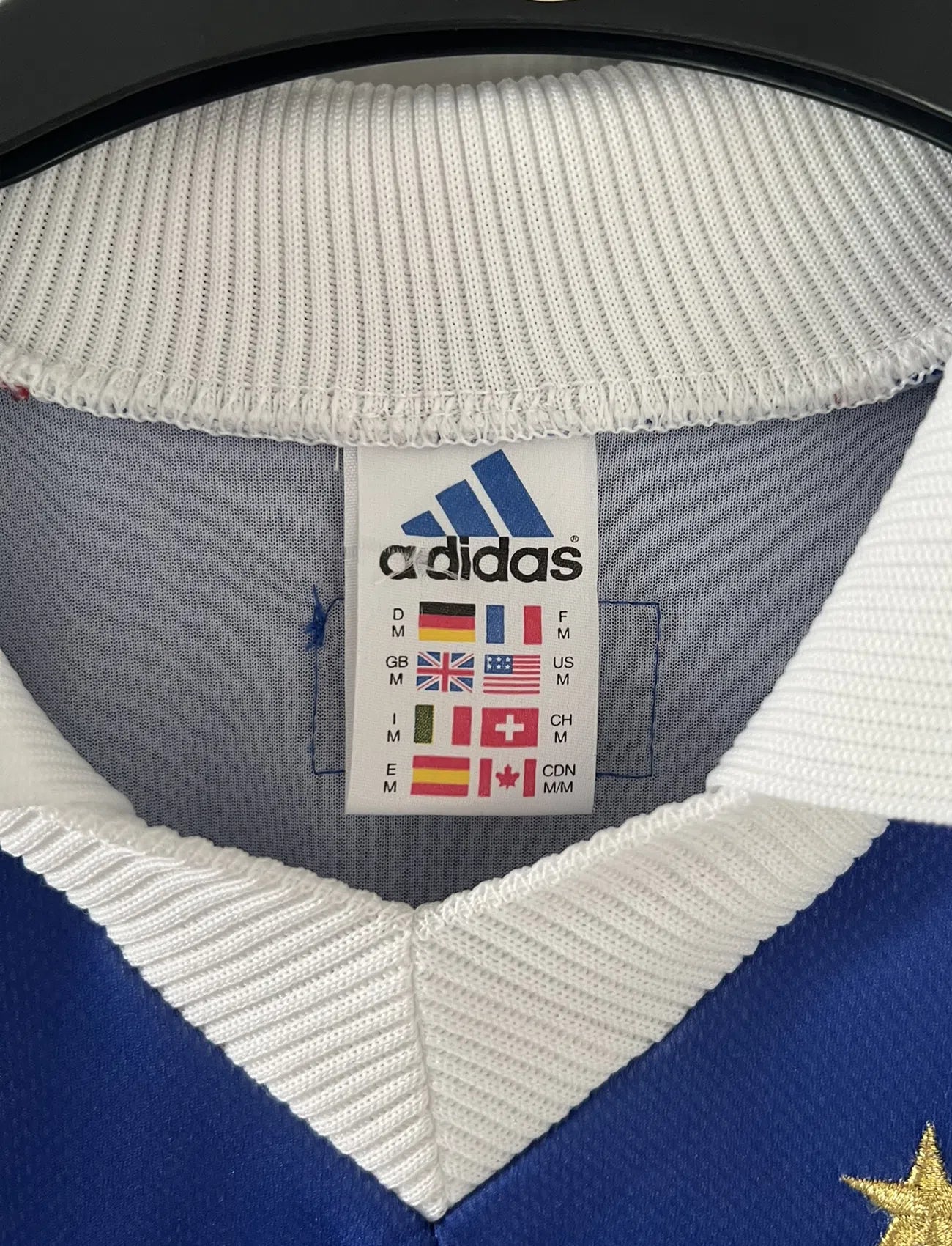 Maillot de foot vintage de l'équipe de france bleu blanc et rouge. Il s'agit du maillot domicile de la coupe du monde 1998. On peut retrouver l'équipementier adidas et le coq avec l'étoile. Le maillot possède la signature pour toi de Didier Deschamps