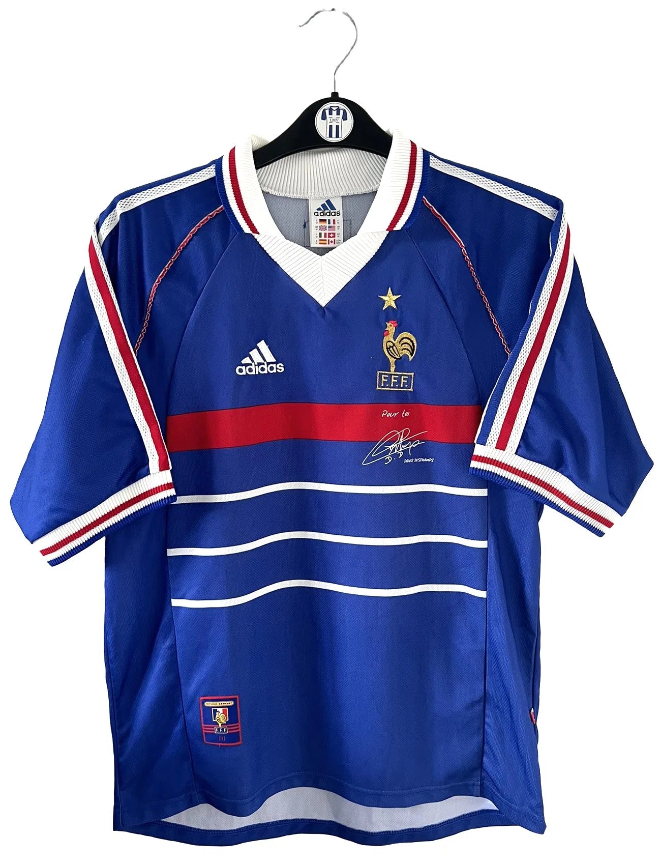 Maillot de foot vintage de l'équipe de france bleu blanc et rouge. Il s'agit du maillot domicile de la coupe du monde 1998. On peut retrouver l'équipementier adidas et le coq avec l'étoile. Le maillot possède la signature pour toi de Didier Deschamps