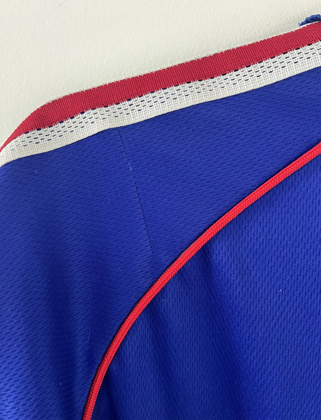 Maillot de foot vintage de l'équipe de france bleu blanc et rouge. Il s'agit du maillot domicile de la coupe du monde 1998. On peut retrouver l'équipementier adidas et le coq sans l'étoile. Le maillot possède la signature pour toi de Zinedine Zidane