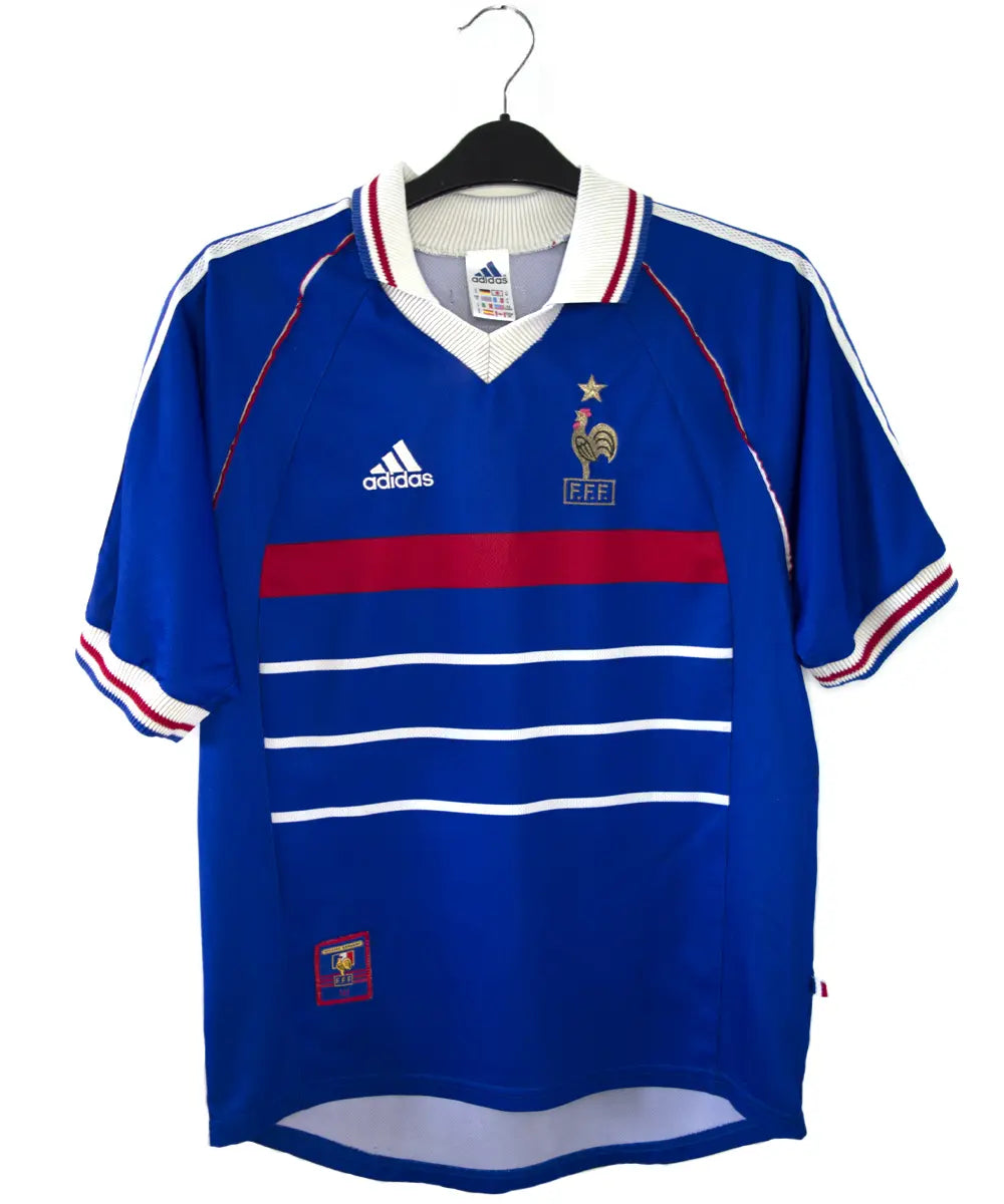 Maillot de foot vintage bleu blanc et rouge de l'équipe de france 1998. On peut retrouver l'équipementier adidas. Le maillot est floqué du numéro 10 Zinedine Zidane