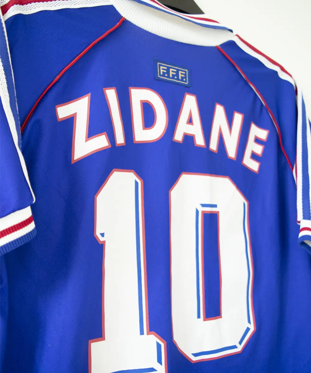 Maillot de foot authentique de l'équipe de france 1998. Le maillot est floqué du numéro 10 Zinedine Zidane. Sur cette photo on peut voir le flocage du maillot de côté
