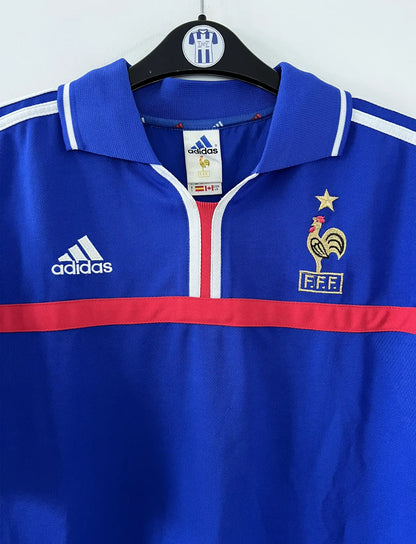 Maillot de foot vintage domicile de l'équipe de france 2000. Le maillot est de couleur bleu blanc et rouge. On peut retrouver l'équipementier adidas. Il s'agit d'un maillot authentique comportant les numéros 647194.