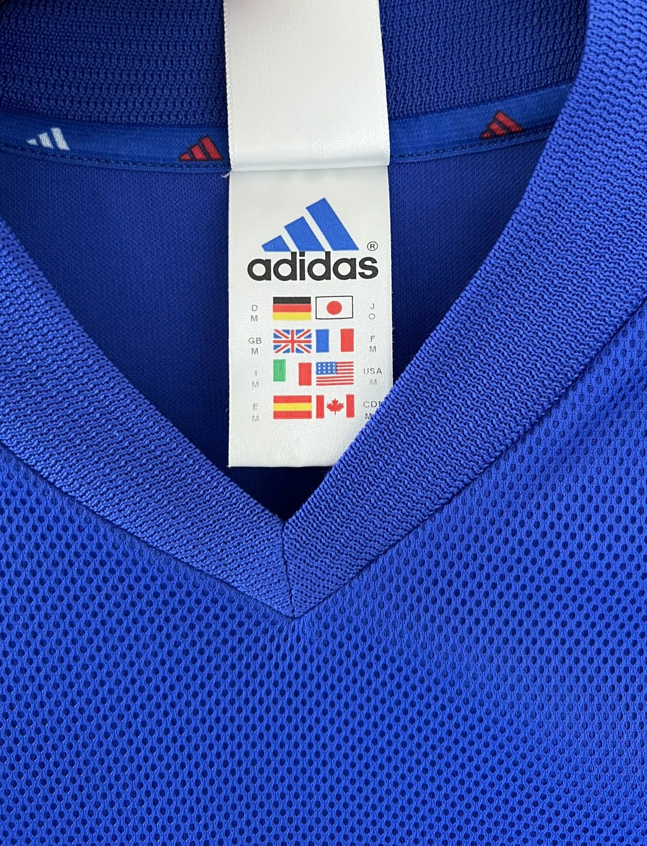 Maillot de foot vintage domicile de l'Equipe de France 2002. Le maillot est de couleur bleu, blanc et rouge. On peut retrouver l'équipementier adidas et le flocage de Zinedine Zidane. Il s'agit d'un maillot authentique. Le maillot possède l'étiquette d'authenticité comportant les numéros 139531.