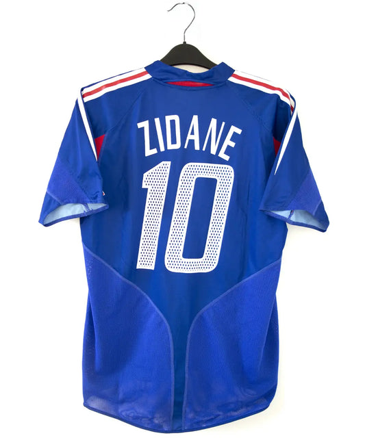 Maillot domicile de l'équipe de france 2004 2006 de couleur bleu blanc et rouge. On peut retrouver l'équipementier adidas. Le maillot est floqué du numéro 10 Zidane