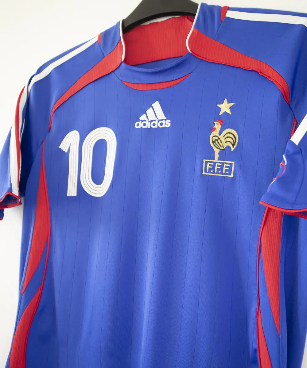 Maillot domicile vintage bleu de l'équipe de france 2006. On peut retrouver l'équipementier adidas. Le maillot est floqué du numéro 10 Zinedine Zidane