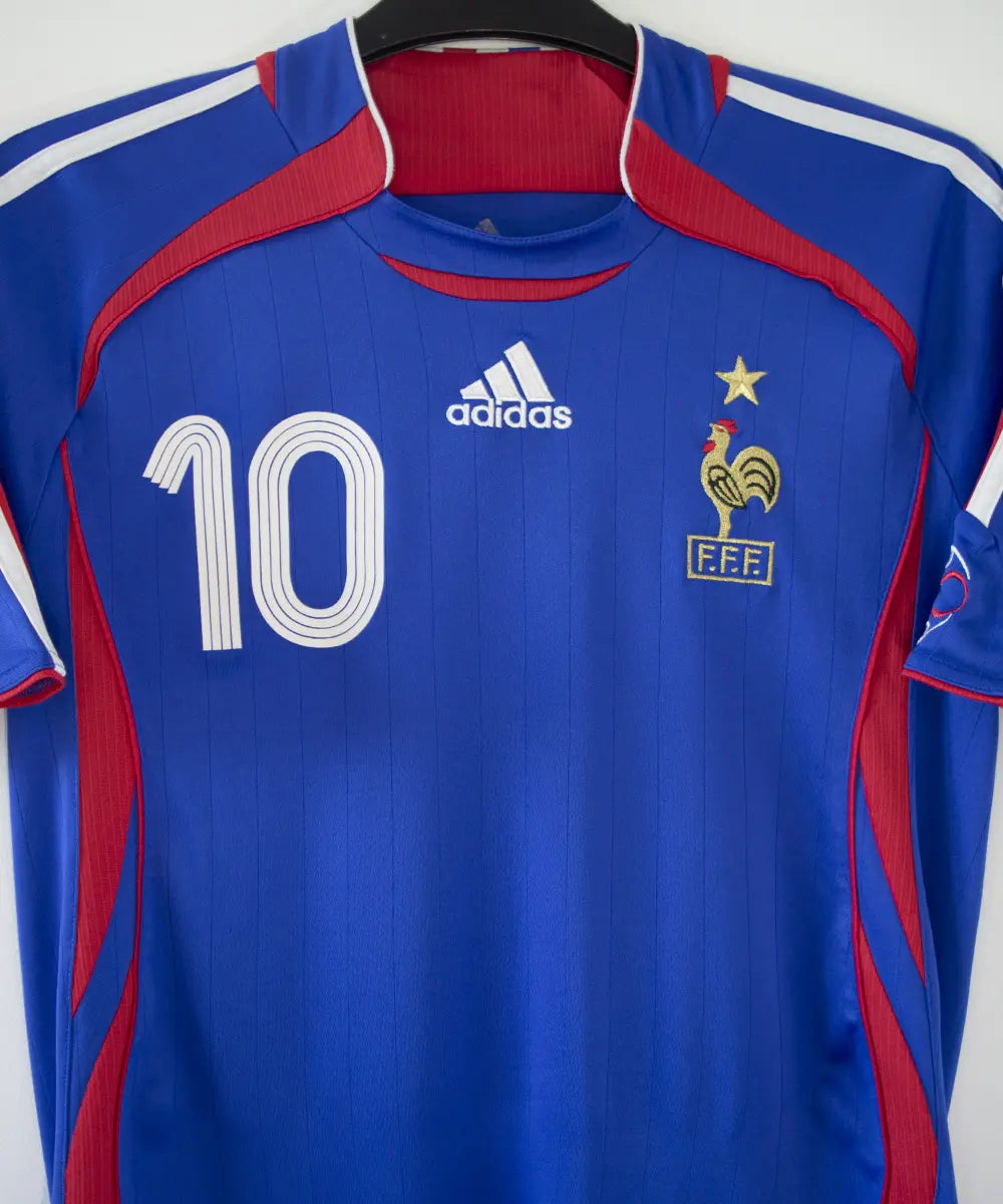 Maillot domicile vintage bleu de l'équipe de france 2006. On peut retrouver l'équipementier adidas. Le maillot est floqué du numéro 10 Zinedine Zidane
