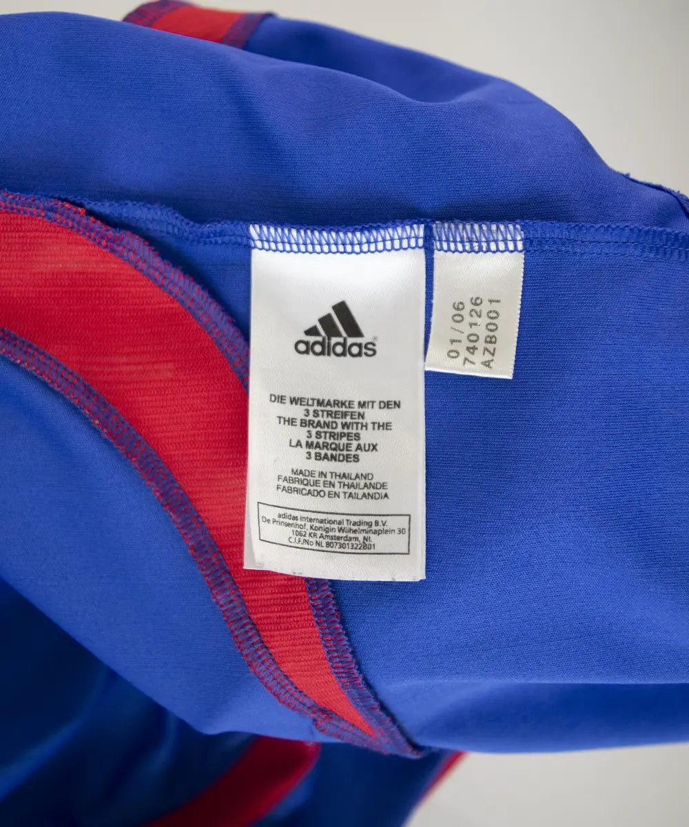 Maillot domicile vintage bleu de l'équipe de france 2006. On peut retrouver l'équipementier adidas. Le maillot est floqué du numéro 10 Zinedine Zidane. Sur cette photo on peut voir l'étiquette du maillot comportant les numéros 740126