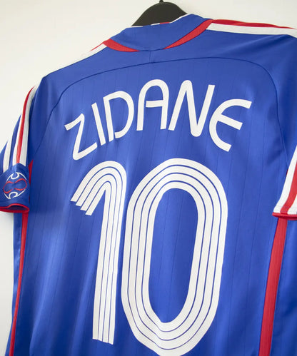 Maillot domicile vintage bleu de l'équipe de france 2006. On peut retrouver l'équipementier adidas. Le maillot est floqué du numéro 10 Zinedine Zidane