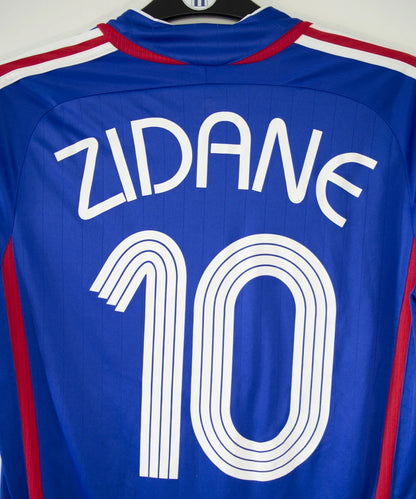 Maillot de foot vintage domicile bleu, blanc et rouge de l'équipe de france 2006. On peut retrouver l'équipementier adidas. Le maillot est floqué du numéro 10 Zinedine Zidane. Il s'agit d'un maillot authentique