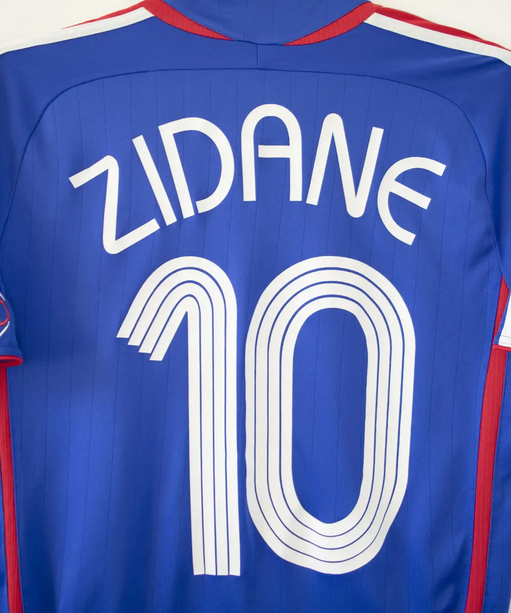 Maillot domicile vintage bleu de l'équipe de france 2006. On peut retrouver l'équipementier adidas. Le maillot est floqué du numéro 10 Zinedine Zidane
