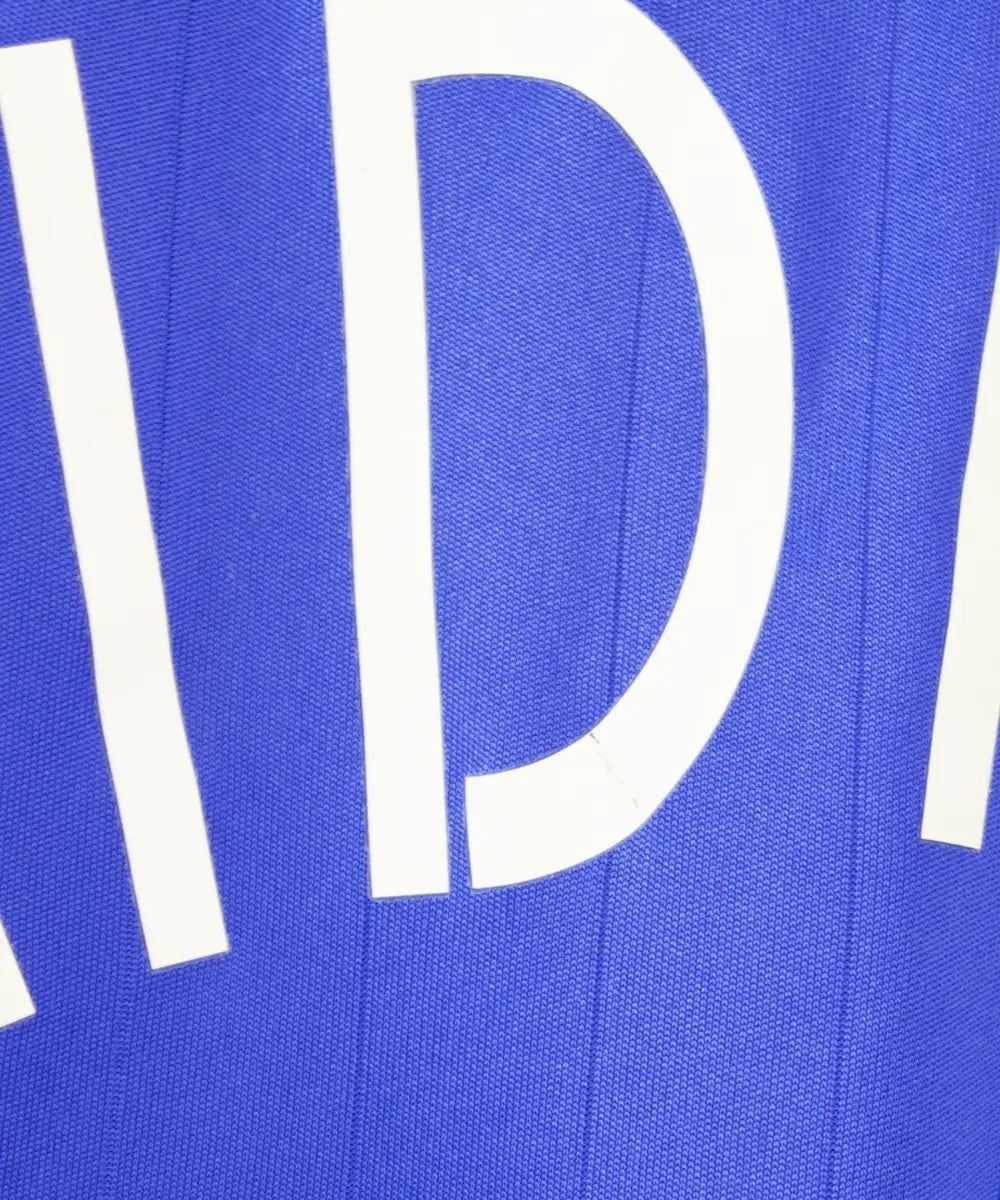 Maillot domicile de l'équipe de france porté lors de la coupe du monde 2006. Le maillot est de couleur bleu blanc et rouge. On peut retrouver l'équipementier adidas. Le maillot est floqué du numéro 10 Zinedine Zidane. Sur cette photo on peut apercevoir que la lettre D est très légèrement abimée