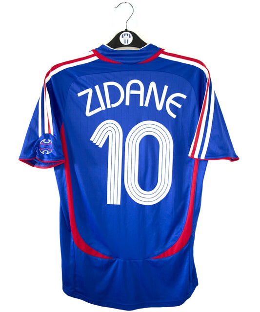 Maillot de foot vintage domicile bleu, blanc et rouge de l'équipe de france 2006. On peut retrouver l'équipementier adidas. Le maillot est floqué du numéro 10 Zinedine Zidane. Il s'agit d'un maillot authentique