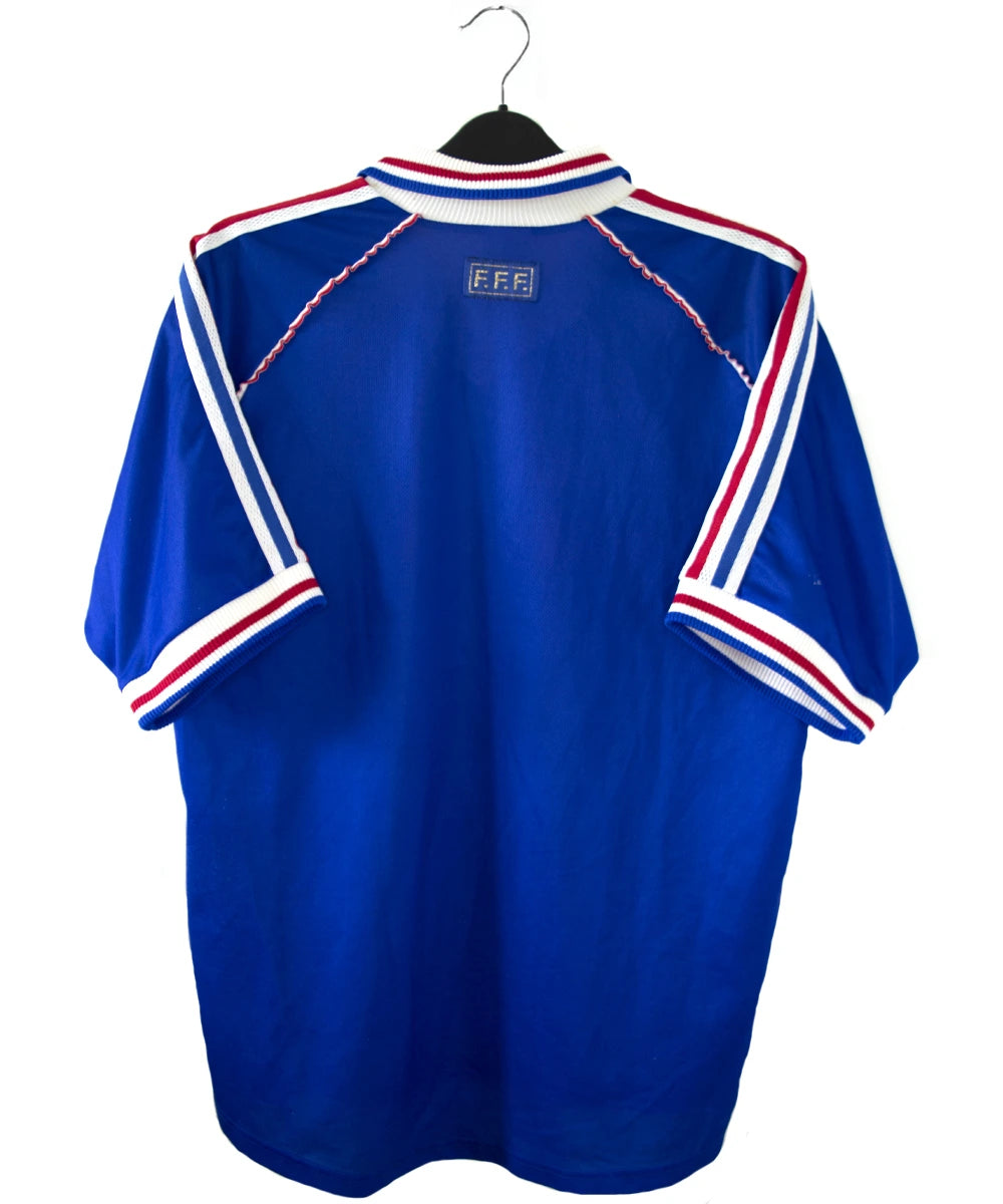 Maillot de foot vintage bleu, blanc et rouge de l'équipe de france 1998. On peut retrouver l'équipementier adidas. Il s'agit d'un maillot authentique édité avant la finale de la coupe du monde car celui-ci ne possède pas l'étoile.