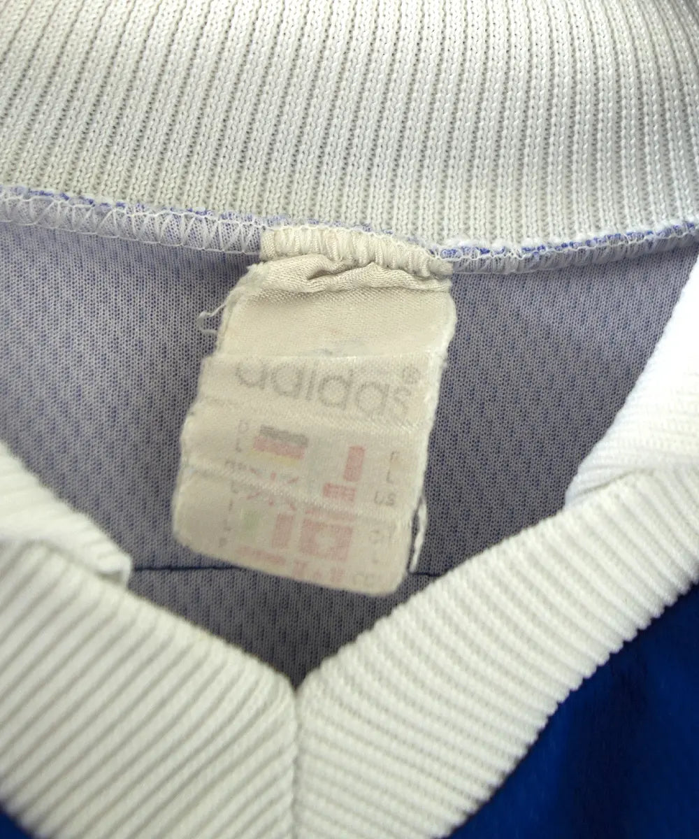 Maillot domicile bleu adidas de l'équipe de france 1998. Le maillot est floqué du numéro 10 Zinedine Zidane. Sur cette photo on peut voir l'étiquette du maillot