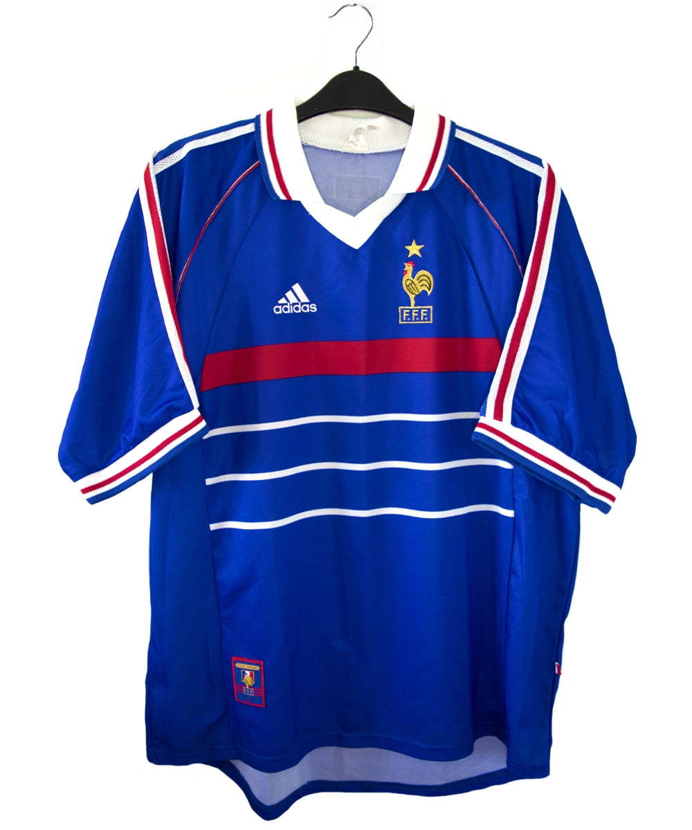 Maillot de foot vintage domicile bleu, blanc et rouge de l'équipe de france 1998. On peut voir l'équipementier adidas. Le maillot est floqué du numéro 10 Zidane. Il s'agit d'un maillot authentique d'époque