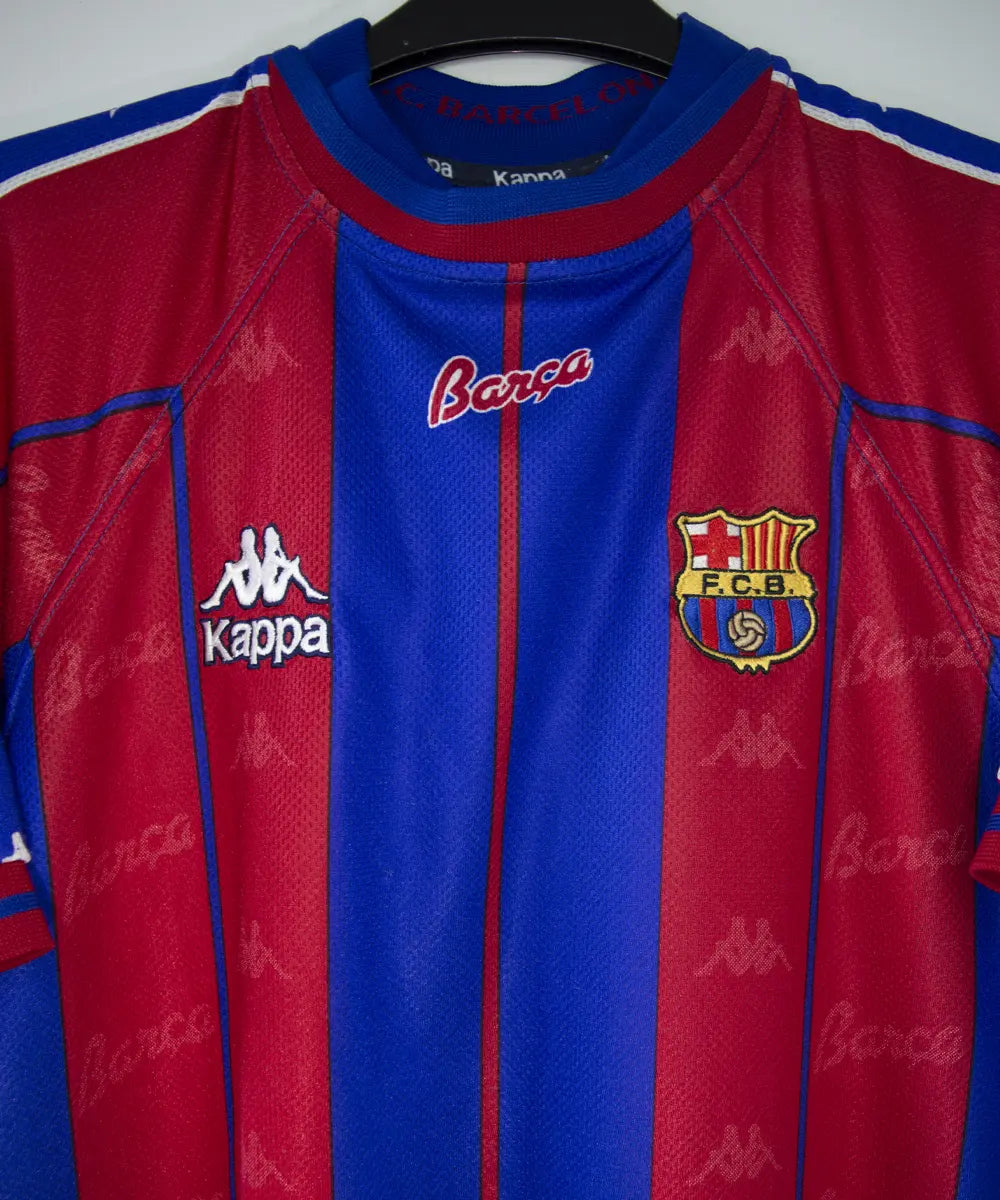 Maillot domicile du fc barcelone de la saison 1997-1998. Le maillot est de couleur rouge et bleu. On peut retrouver l'équipementier kappa