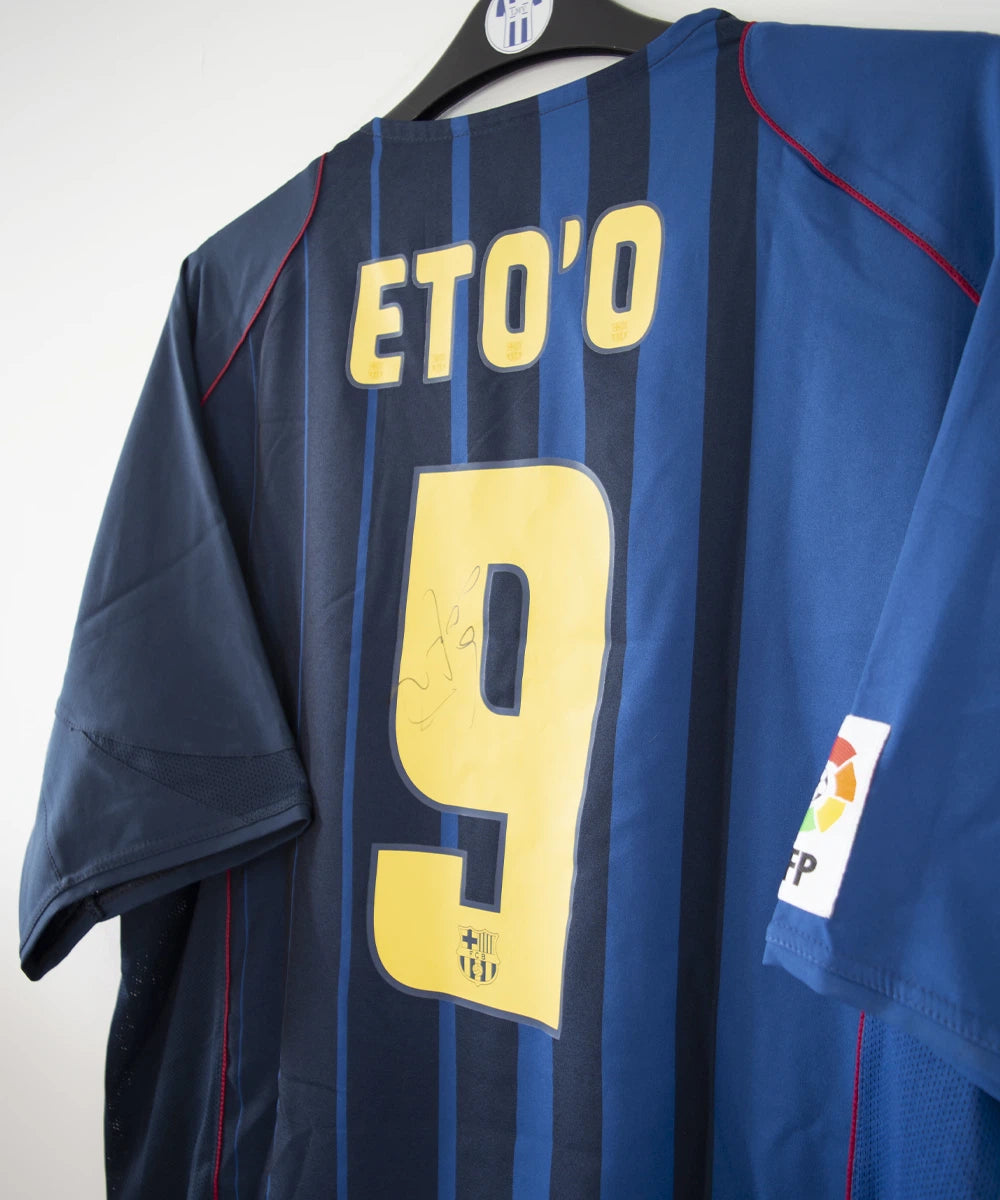 Maillot de foot vintage bleu du FC Barcelone de la saison 2004/2005. On peut retrouver l'équipementier nike. Le maillot est floqué du numéro 9 Samuel Eto'o. On peut voir également sur le maillot la signature de Eto'o. Il s'agit d'un maillot authentique