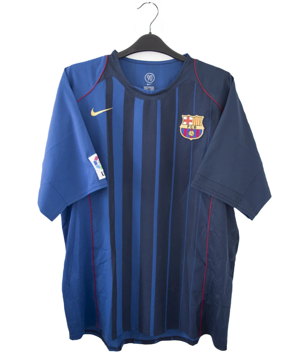 Maillot de foot vintage bleu du FC Barcelone de la saison 2004/2005. On peut retrouver l'équipementier nike. Le maillot est floqué du numéro 9 Samuel Eto'o. On peut voir également sur le maillot la signature de Eto'o. Il s'agit d'un maillot authentique