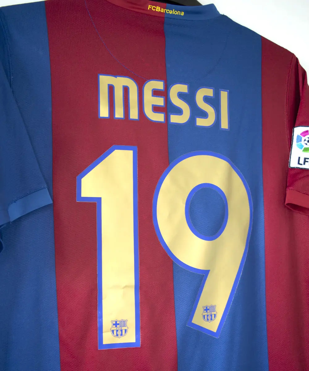 Maillot domicile de près du FC Barcelone de la saison 2006/2007 rouge et bleu. Le maillot est floqué du numéro 19 Messi. On peut retrouver l'équipementier nike sur le maillot