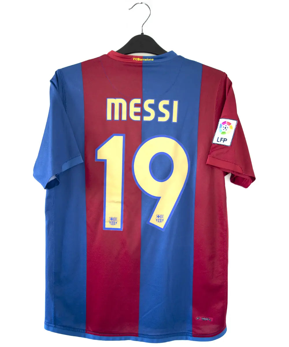 Maillot domicile du FC Barcelone de la saison 2006/2007 rouge et bleu. Le maillot est floqué du numéro 19 Messi. On peut retrouver l'équipementier nike sur le maillot