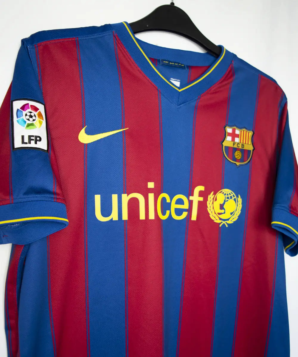 Maillot domicile du barca de la saison 2009-2010. Le maillot est de couleur bleu et rouge. On peut retrouver l'équipementier nike et le sponsor unicef.