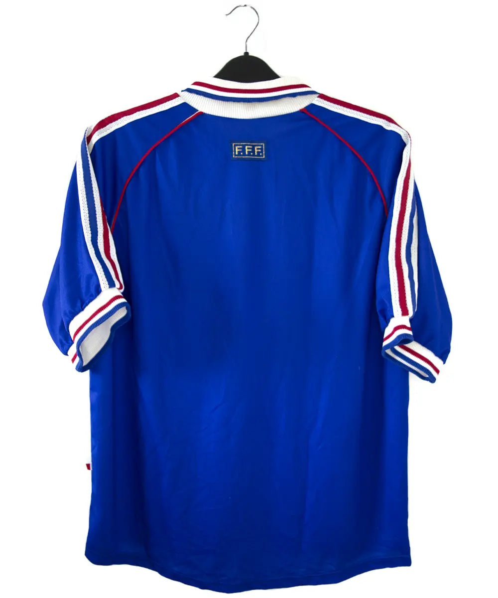 Maillot de foot vintage domicile bleu blanc et rouge de l'équipe de france 1998. On peut retrouver l'équipementier adidas. Le maillot possède la signature pour toi zinedine zidane. Il s'agit d'un maillot authentique