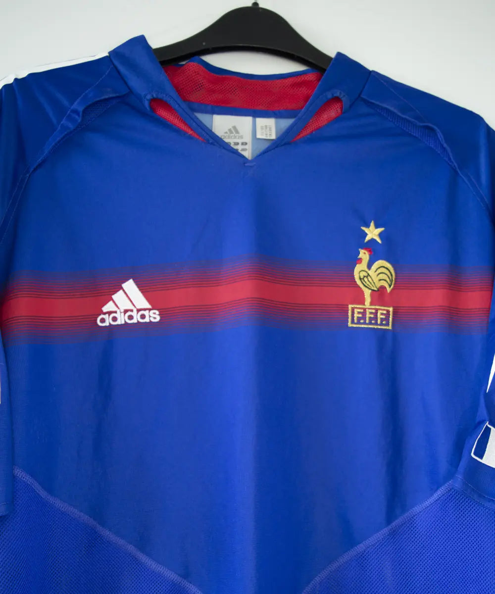 Maillot bleu blanc et rouge de l'équipe de france 2004. On peut retrouver l'équipementier adidas