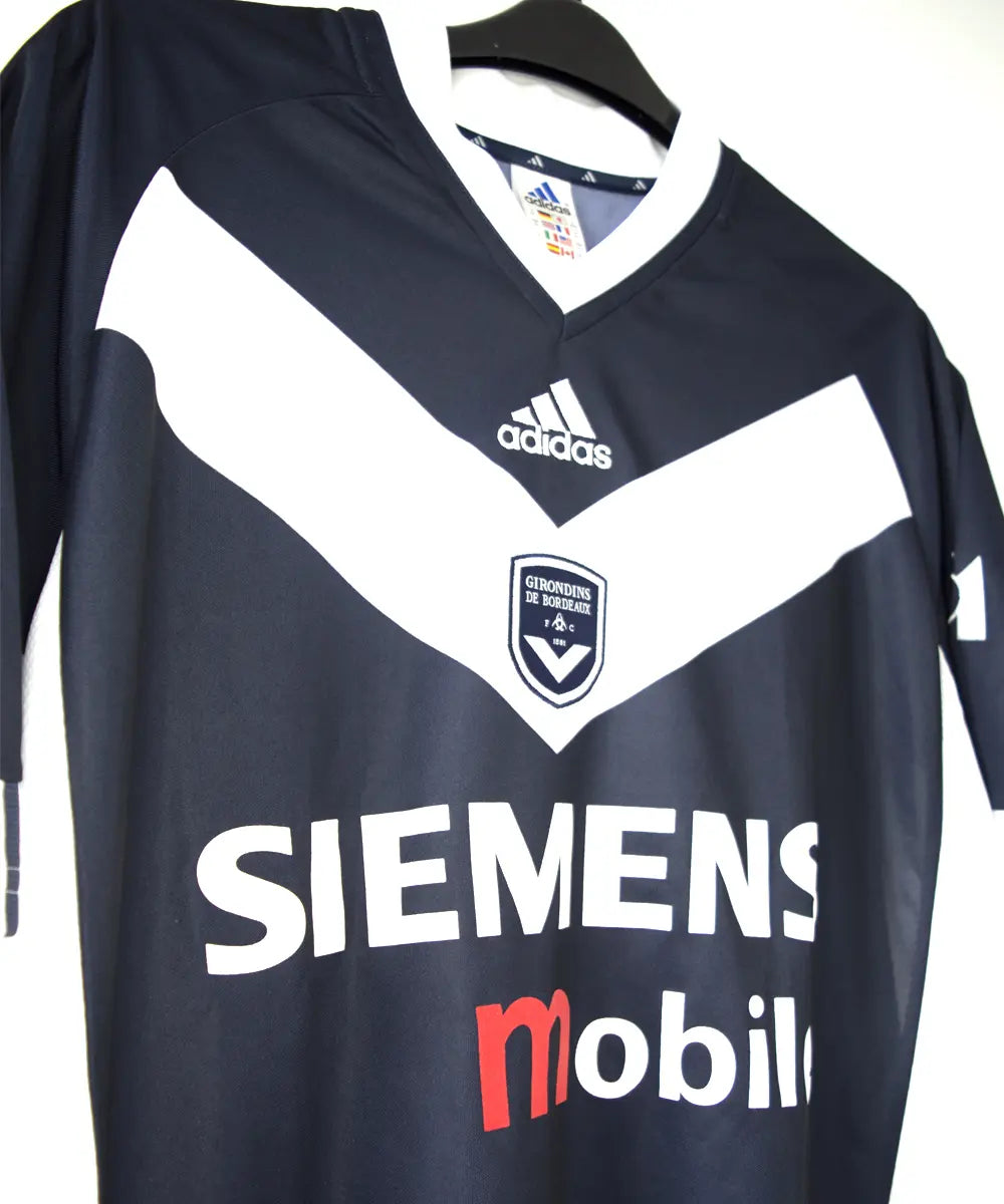 Maillot domicile de côté des girondins de bordeaux 2001-2002. Le maillot est de couleur bleu et blanc. On peut retrouver le sponsor siemens mobile et l'équipementier adidas.