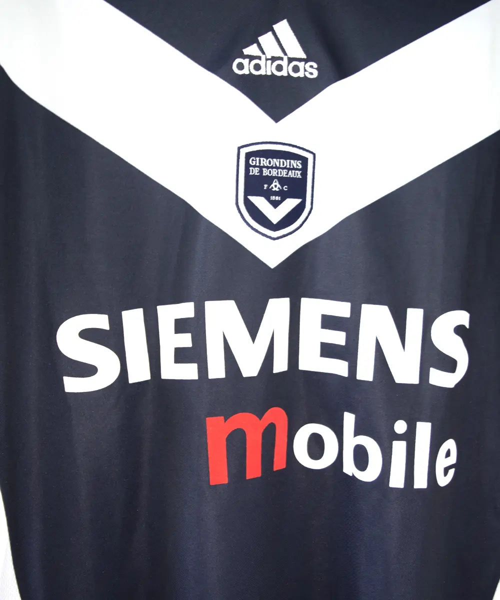 Maillot domicile de près des girondins de bordeaux 2001-2002. Le maillot est de couleur bleu et blanc. On peut retrouver le sponsor siemens mobile et l'équipementier adidas.