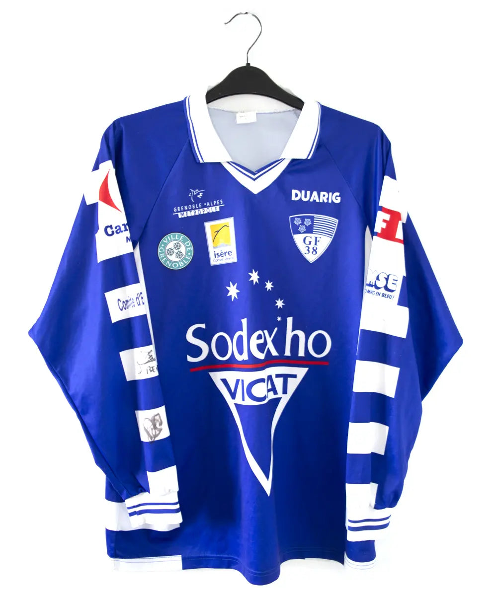 Maillot domicile de grenoble de la saison 1999/2000. On peut retrouver l'équipementier duarig et le sponsor sodexo. Le maillot est de couleur bleu et blanc.