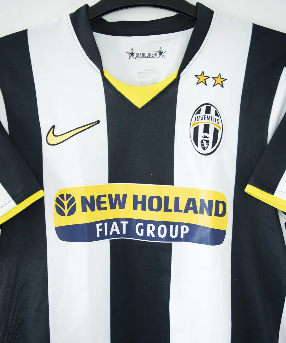 Maillot vintage domicile noir, blanc et jaune, de la juventus de la saison 2008-2009. On peut retrouver l'équipementier nike et le sponsor new holland