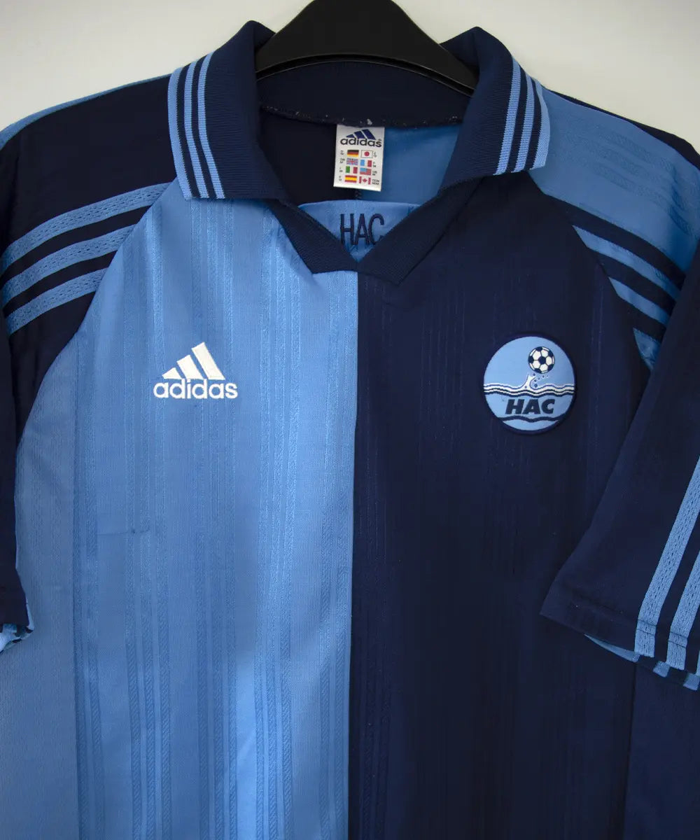 Maillot domicile du havre de la saison 1998-1999 de couleur bleu clair et bleu foncé. On peut voir l'équipementier adidas.