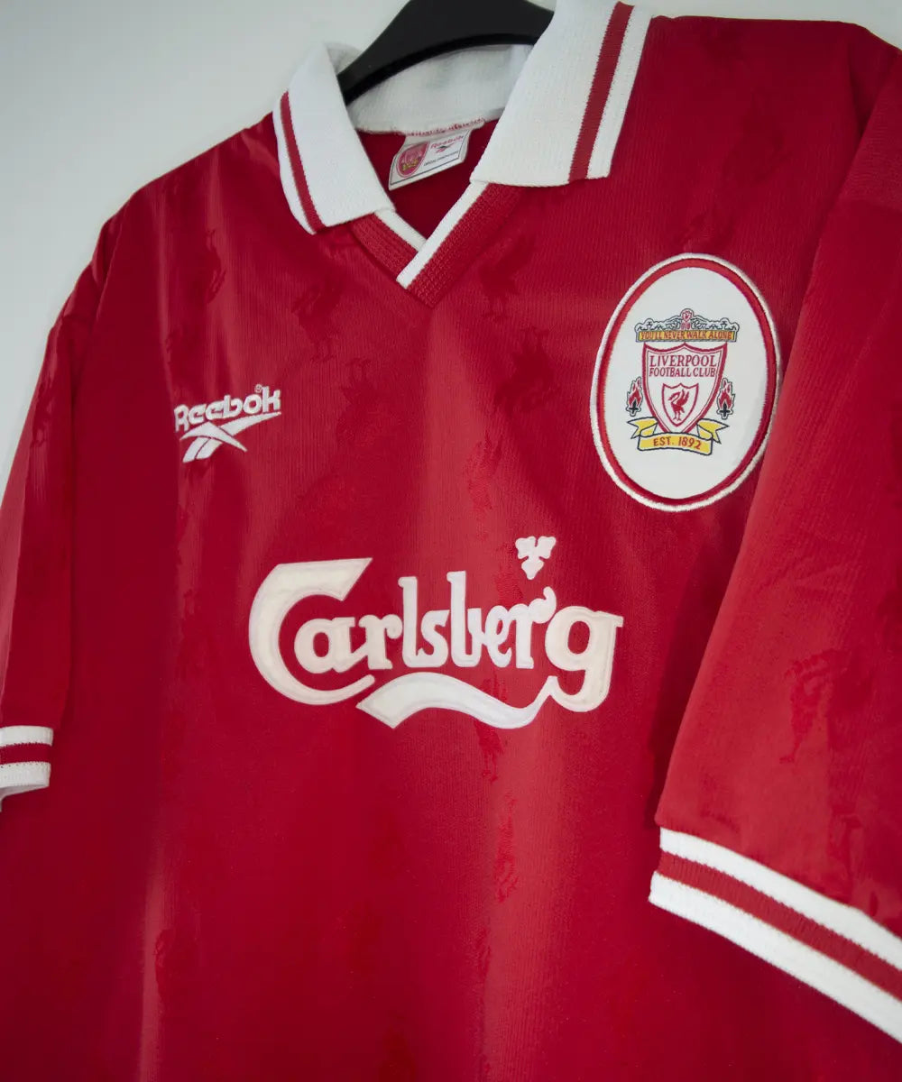 Maillot domicile rouge et blanc de liverpool de la saison 1996-1998. On peut retrouver l'équipementier reebok et le sponsor carlsberg