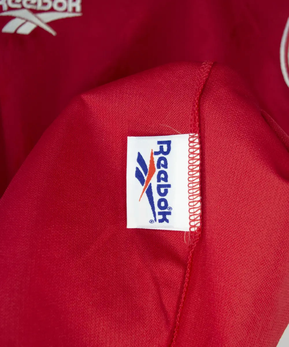 Maillot domicile rouge et blanc de liverpool de la saison 1996-1998. On peut retrouver l'équipementier reebok et le sponsor carlsberg