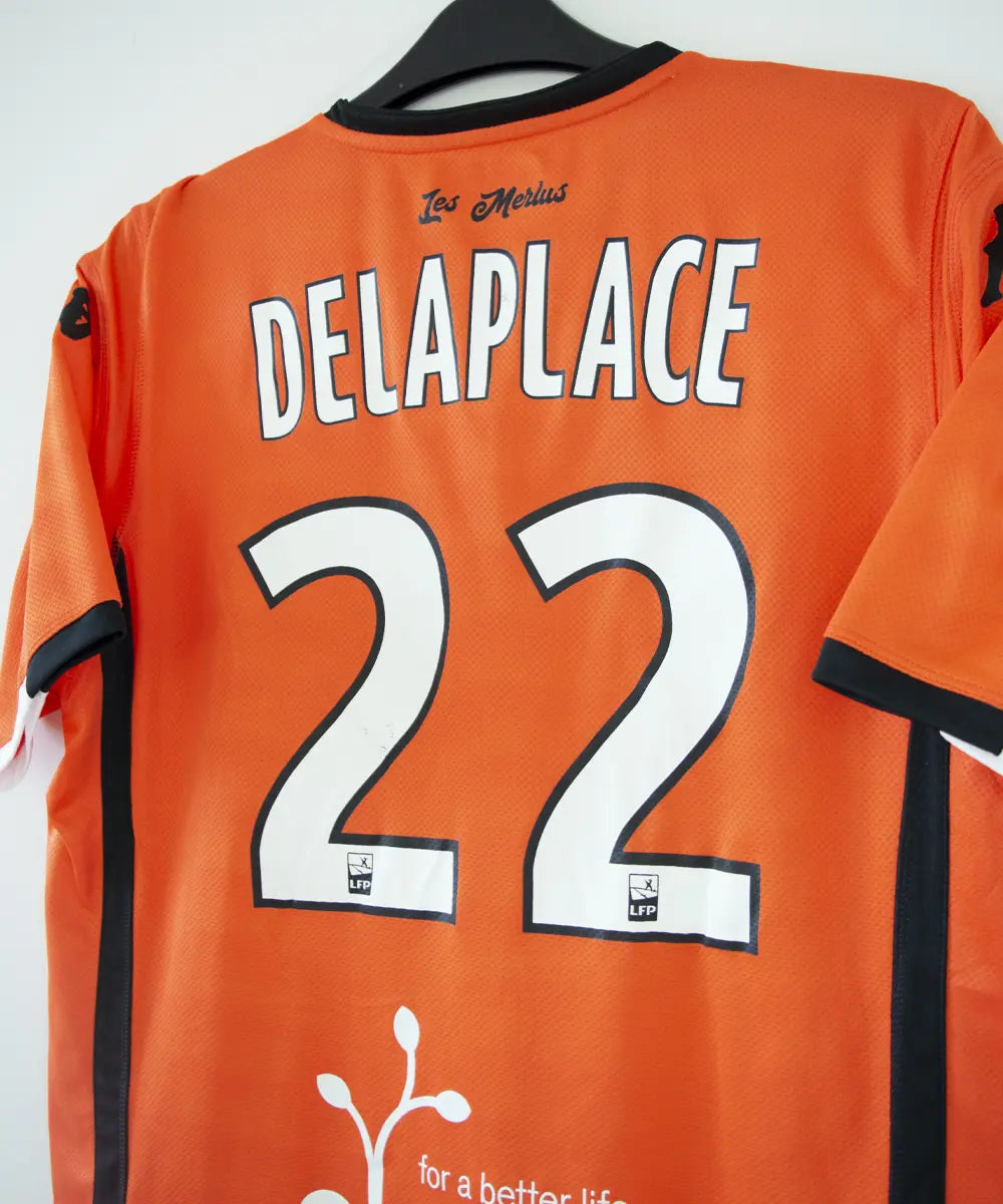 Maillot domicile de Lorient de la saison 2018-2019 de couleur orange, blanc et noir. On peut retrouver l'équipementier kappa et les sponsors jean floc'h, b&b et breizh cola. Le maillot est floqué du numéro 22 delaplace et signé par plusieurs joueurs de l'équipe