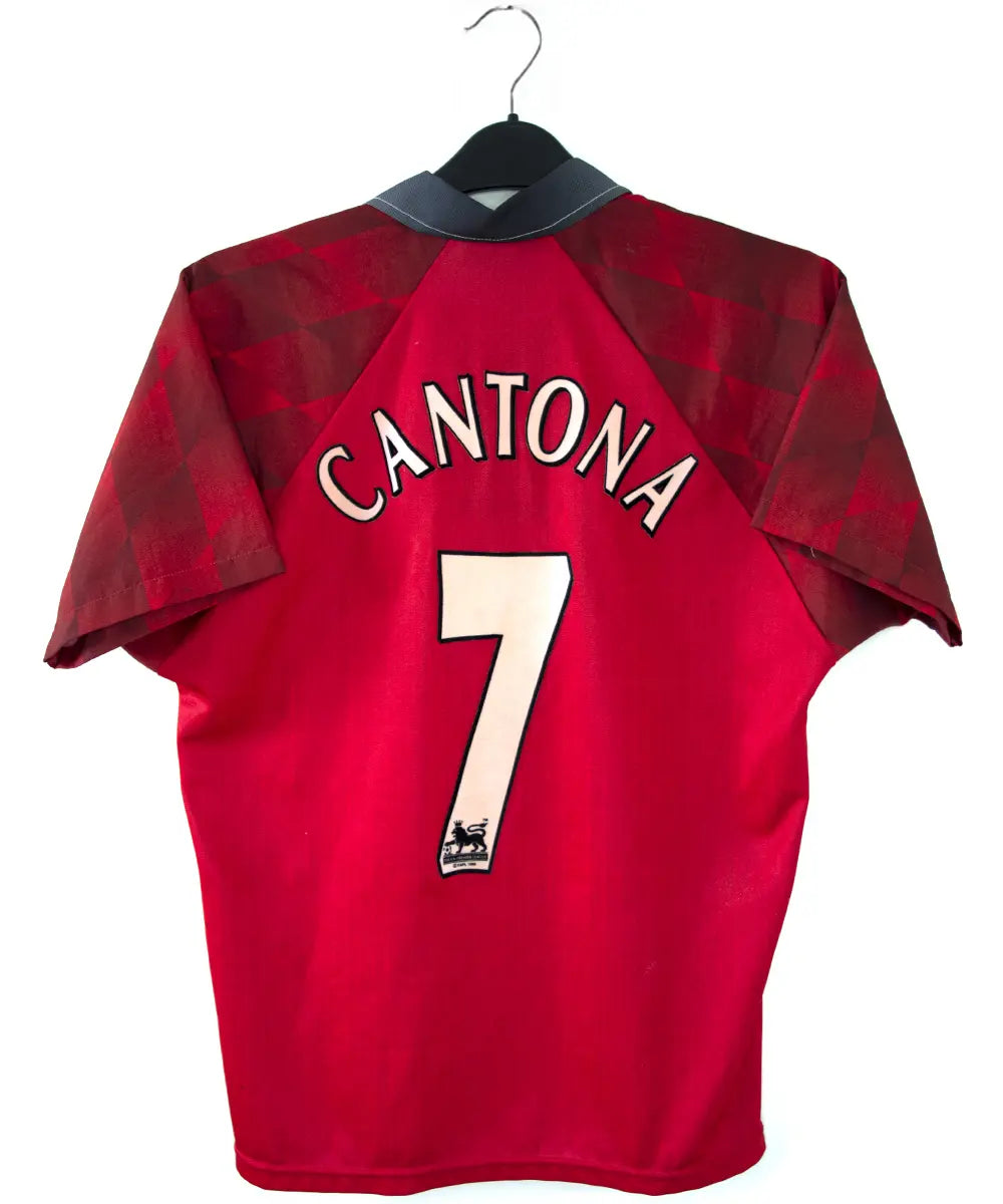 Maillot de foot vintage domicile rouge de manchester united de la saison 1996-1998. On peut retrouver l'équipementier umbro et le sponsor sharp. Le maillot est floqué du numéro 7 Cantona. Il s'agit d'un maillot authentique